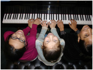 three kids at digital piano